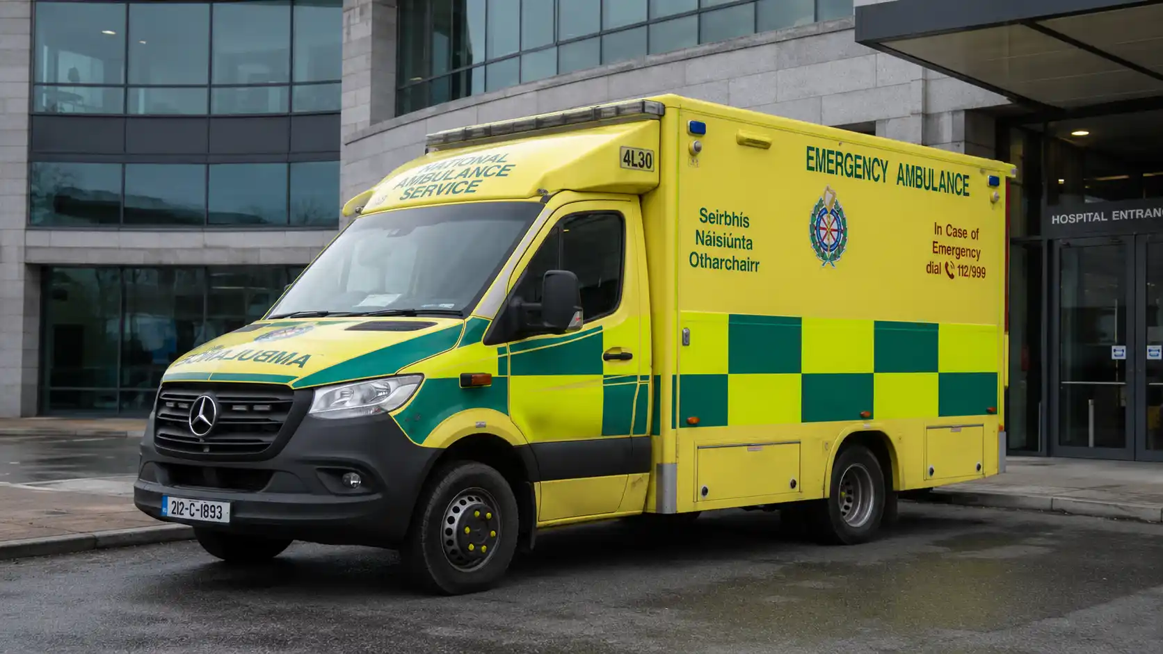 Żółty ambulans National Ambulance Service zaparkowany przed wejściem do szpitala w Irlandii.